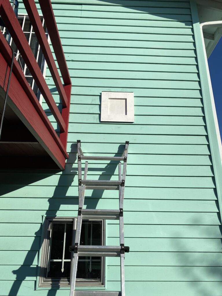 A patch on the side of a house where a gas heater vent used to penetrate