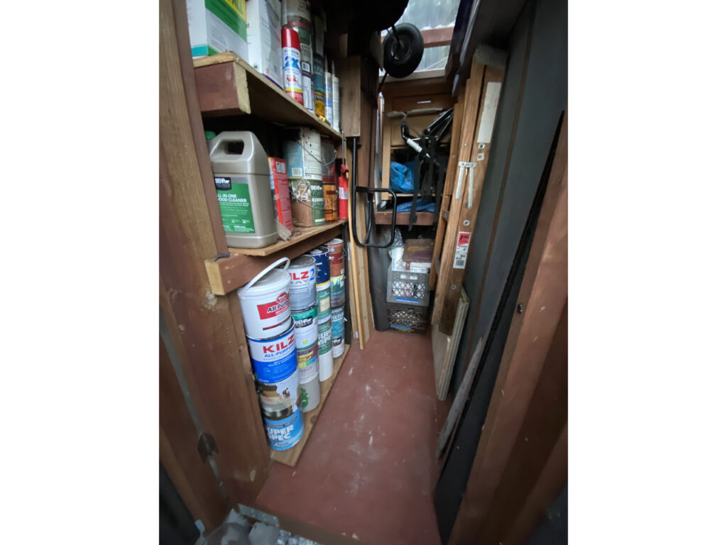 Shelves with paint cans and other supplies neatly stacked on them