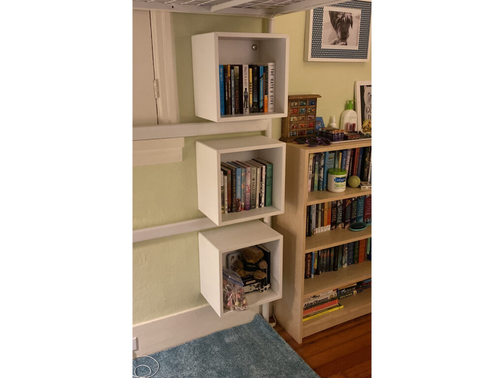 Three "floating" bookshelves mounted on a bedroom wall