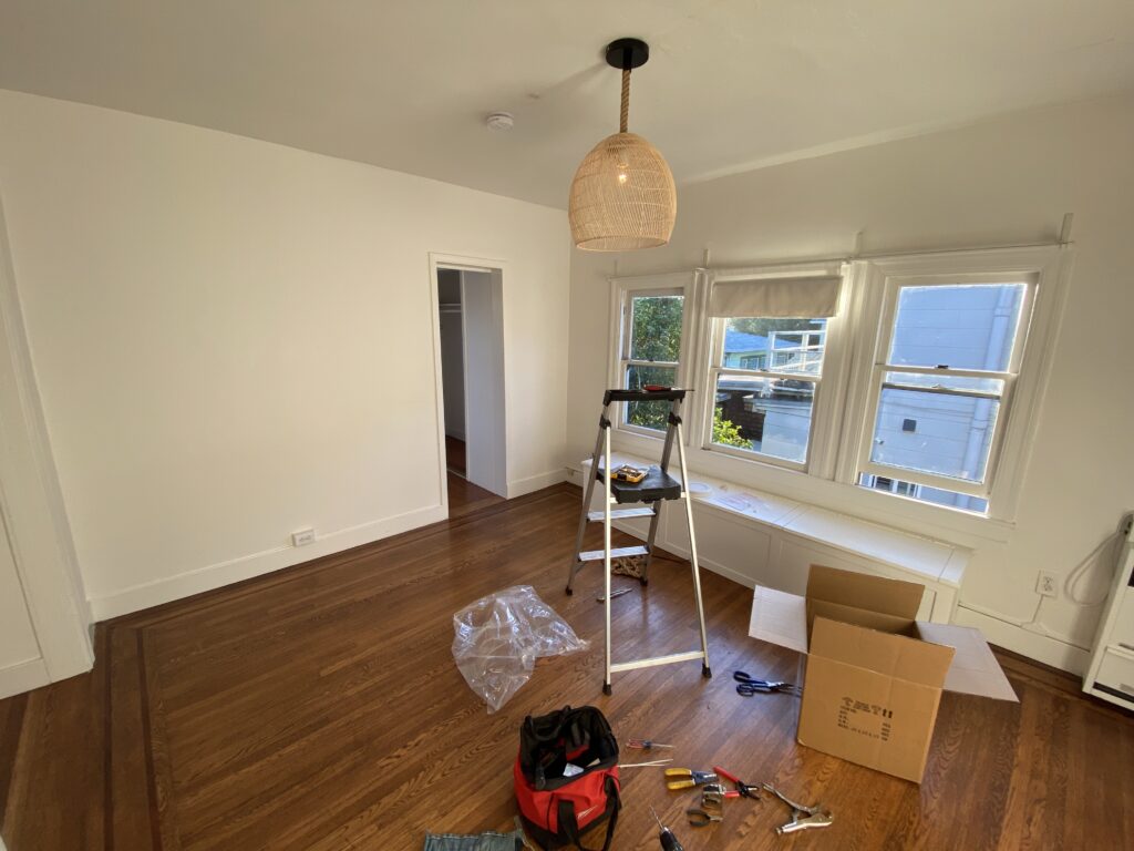 A newly installed ceiling light fixture, with ladder and tools below