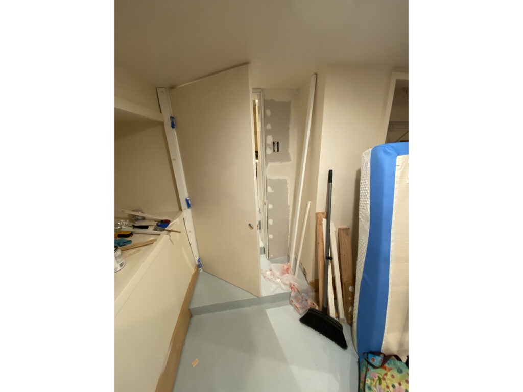 A door being installed between two rooms in a basement
